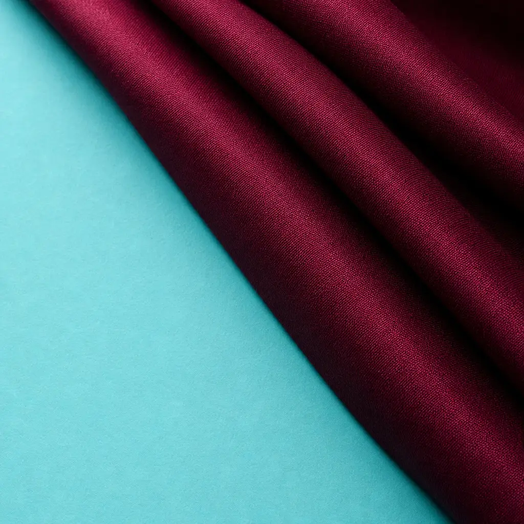 Crimson fabric folded against an aqua ground