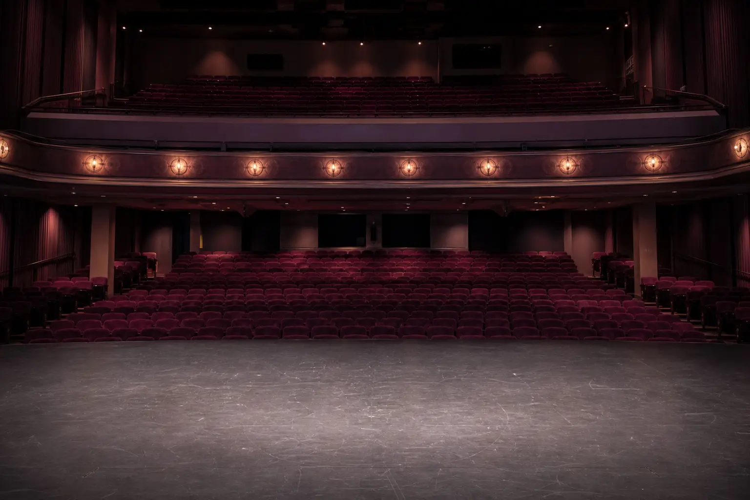 An empty auditorium seen from the stage, house lights at half