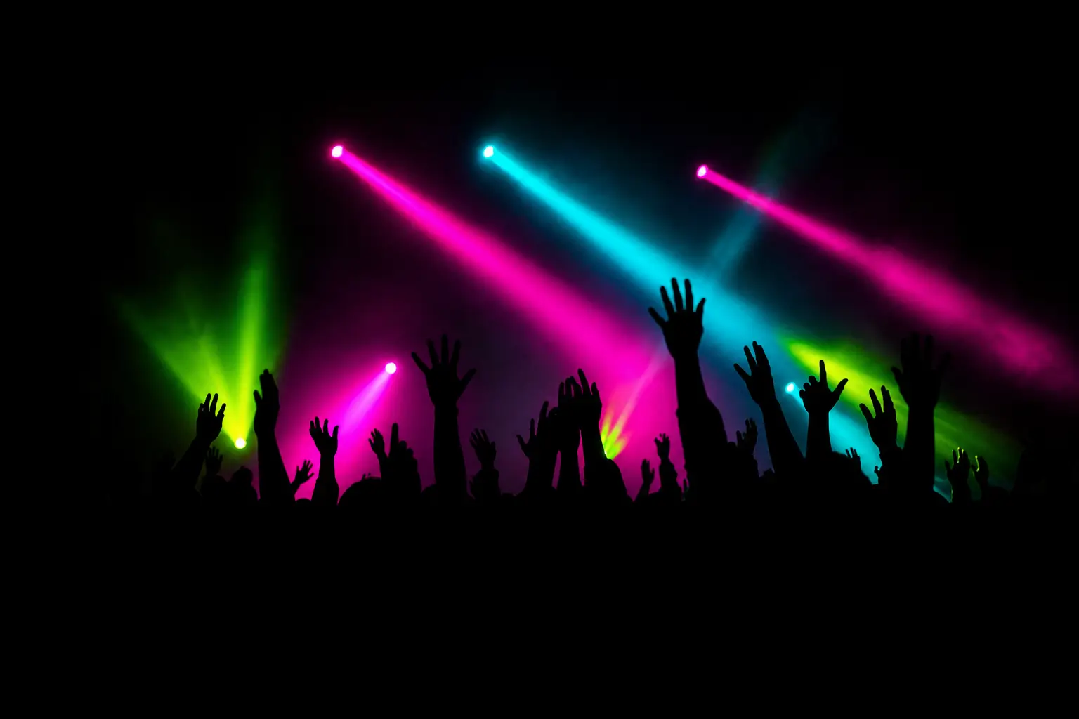 Silhouetted hands raised under magenta and cyan stage light