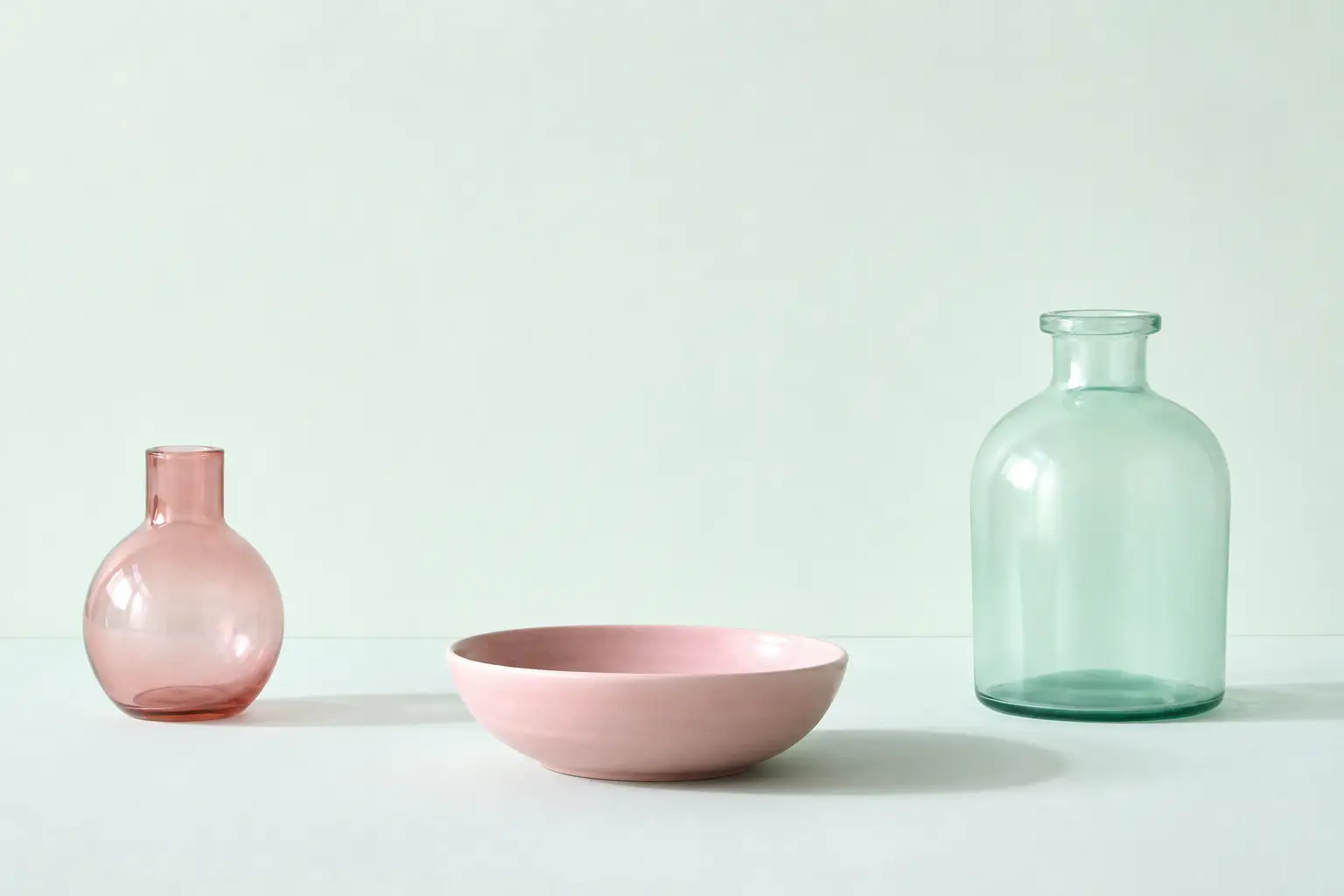 Plain unlabelled vessels on a mint surface with soft shadows