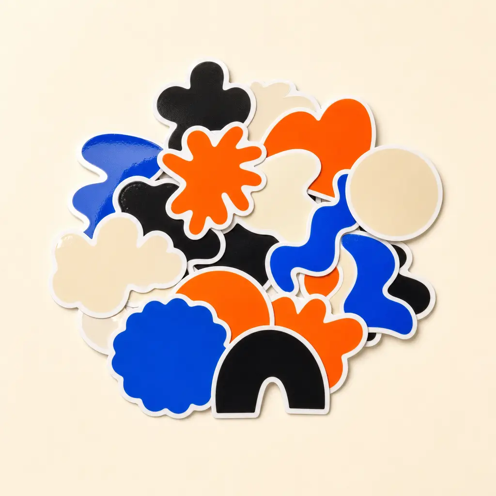 A pile of glossy die-cut stickers in orange and blue