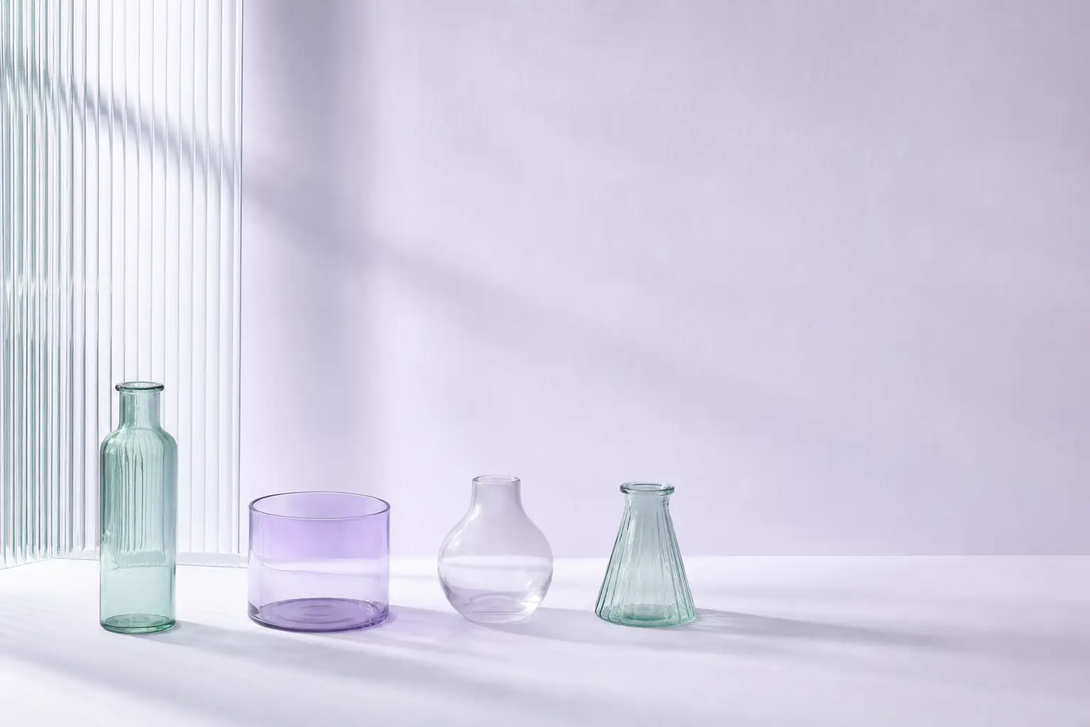 A pale counter with glass vessels arranged in a widely spaced row